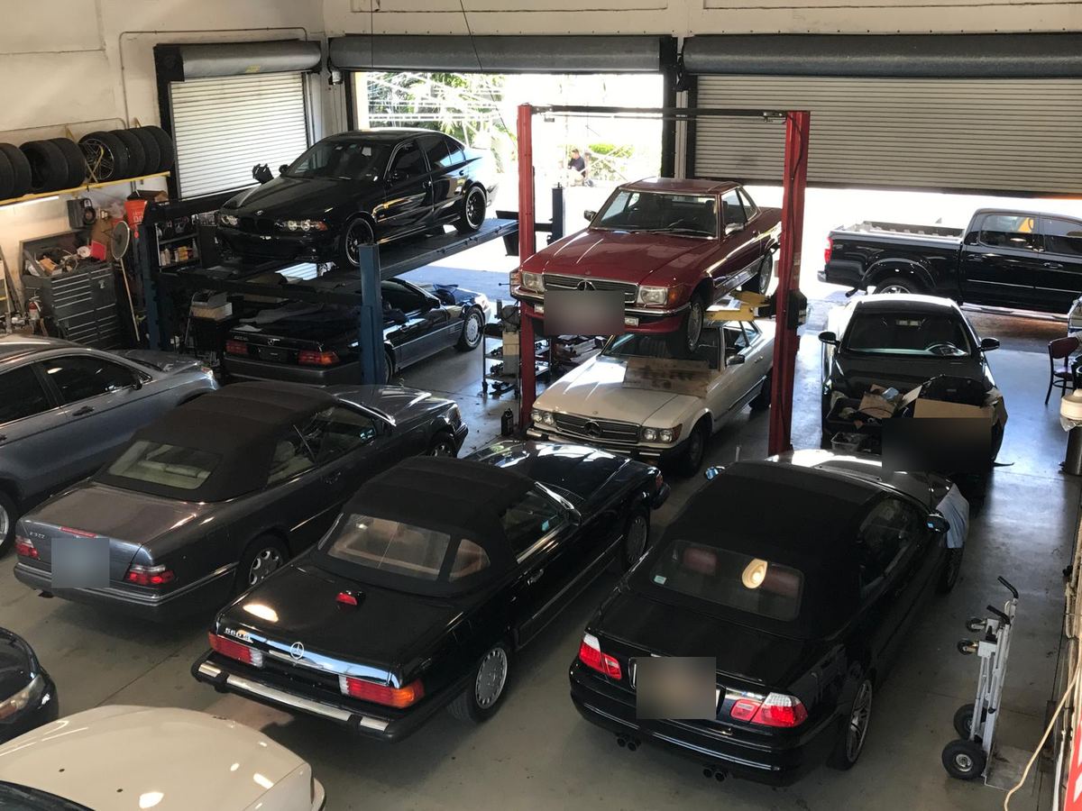 Overhead view of the service bays at Auto Star Co. in Hallandale Beach, with a red Mercedes-Benz SL on the lift