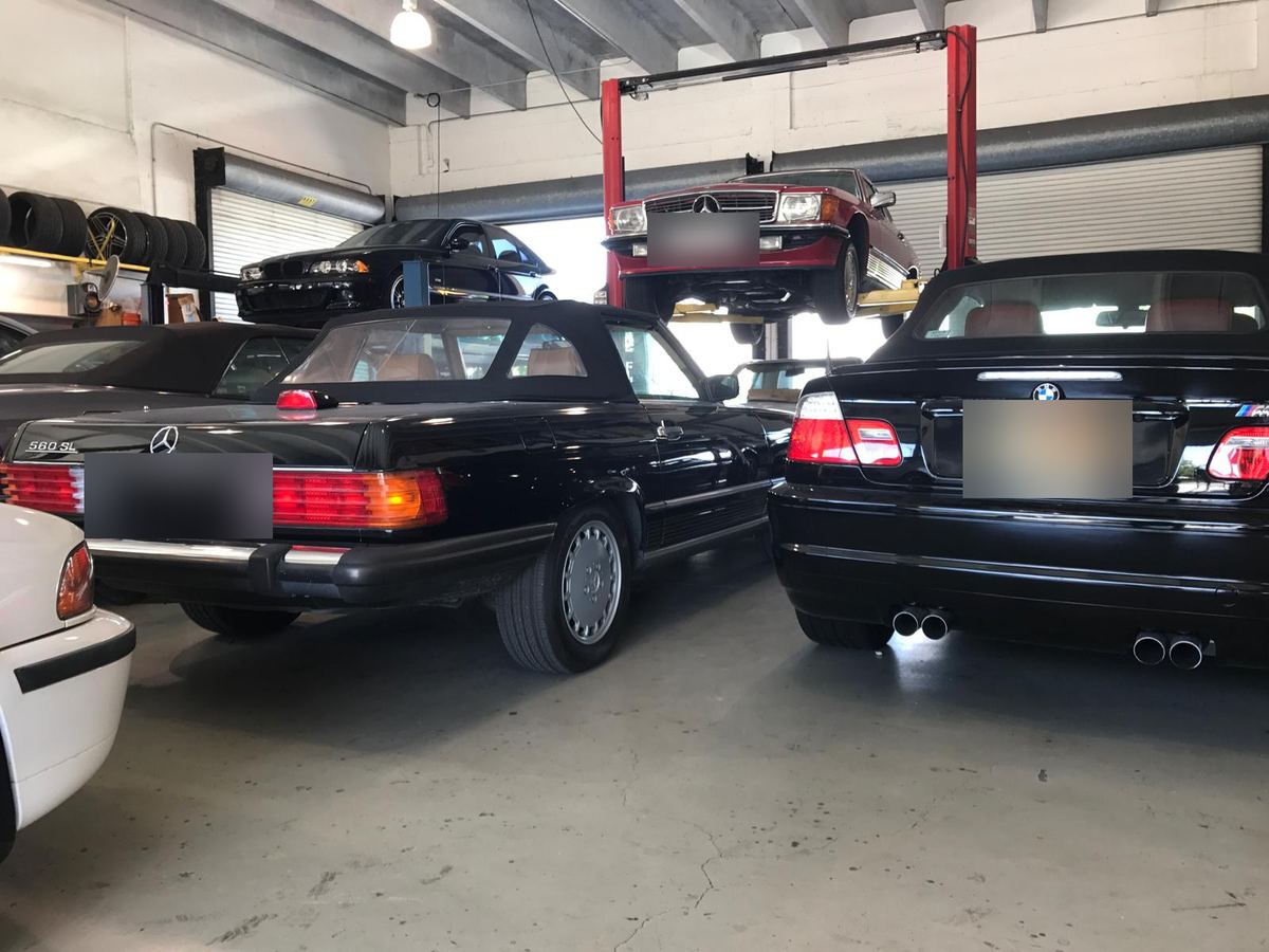Classic Mercedes-Benz SL convertibles and a red SL on a lift at Auto Star Co. in Hallandale Beach